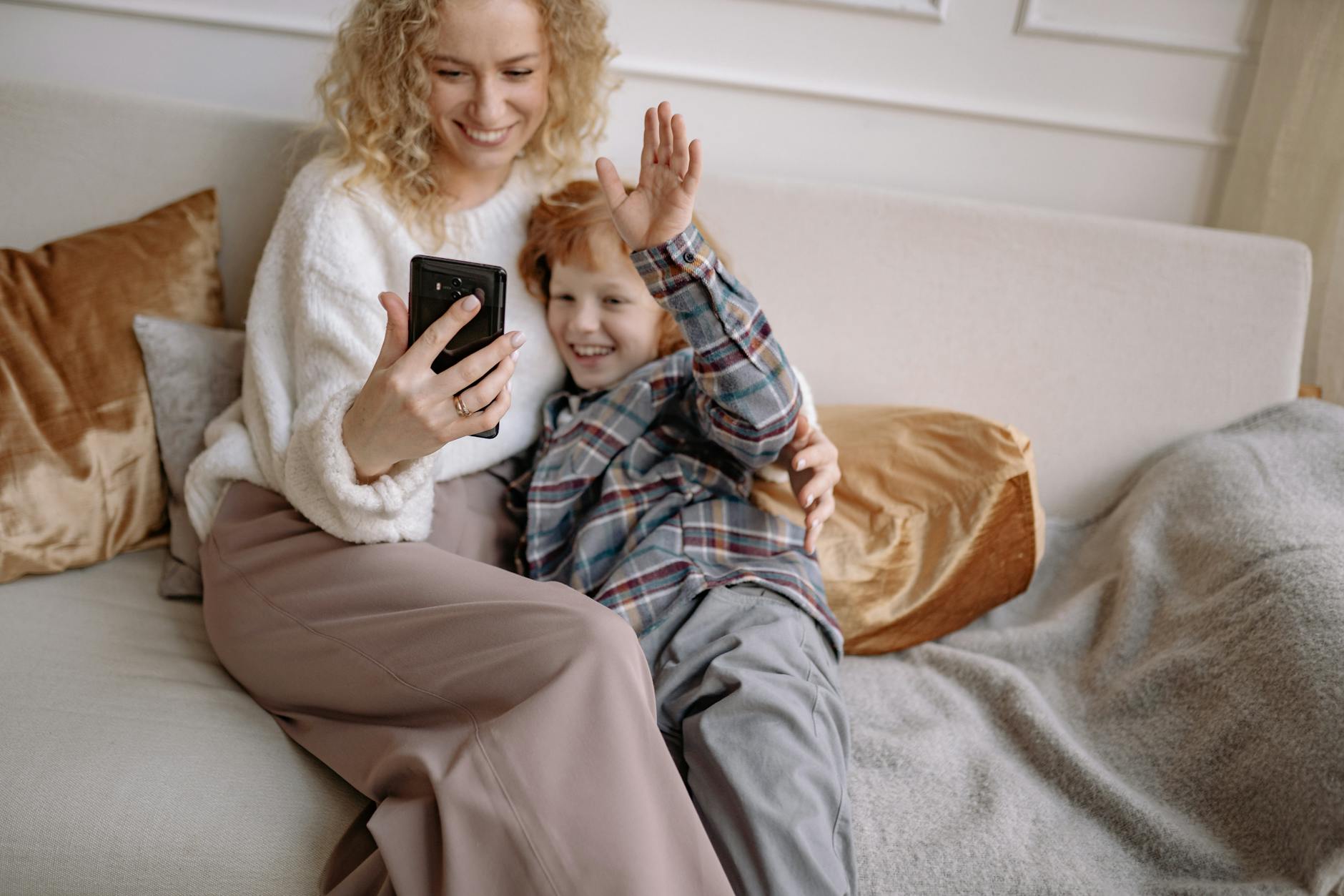 a woman taking a selfie on a couch with her son